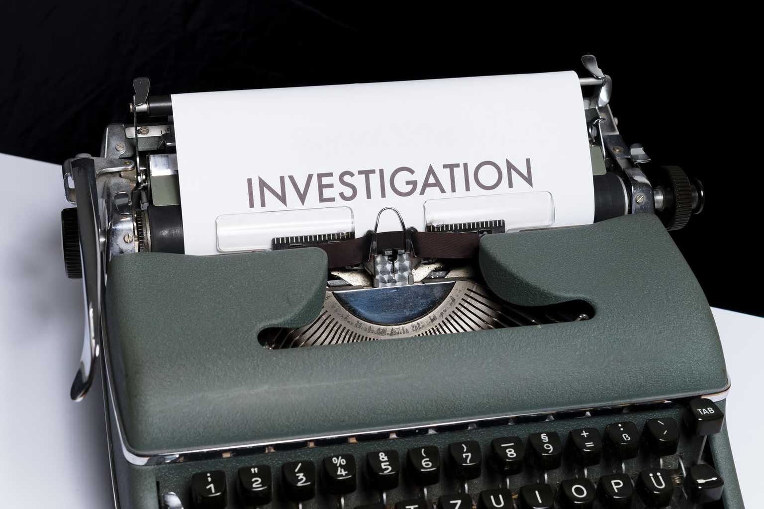 A typewriter with paper loaded that reads: Investigation