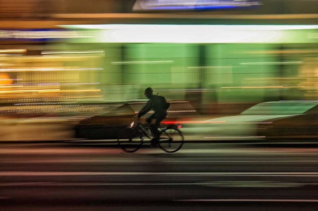Person on a bicycle riding down a busy street